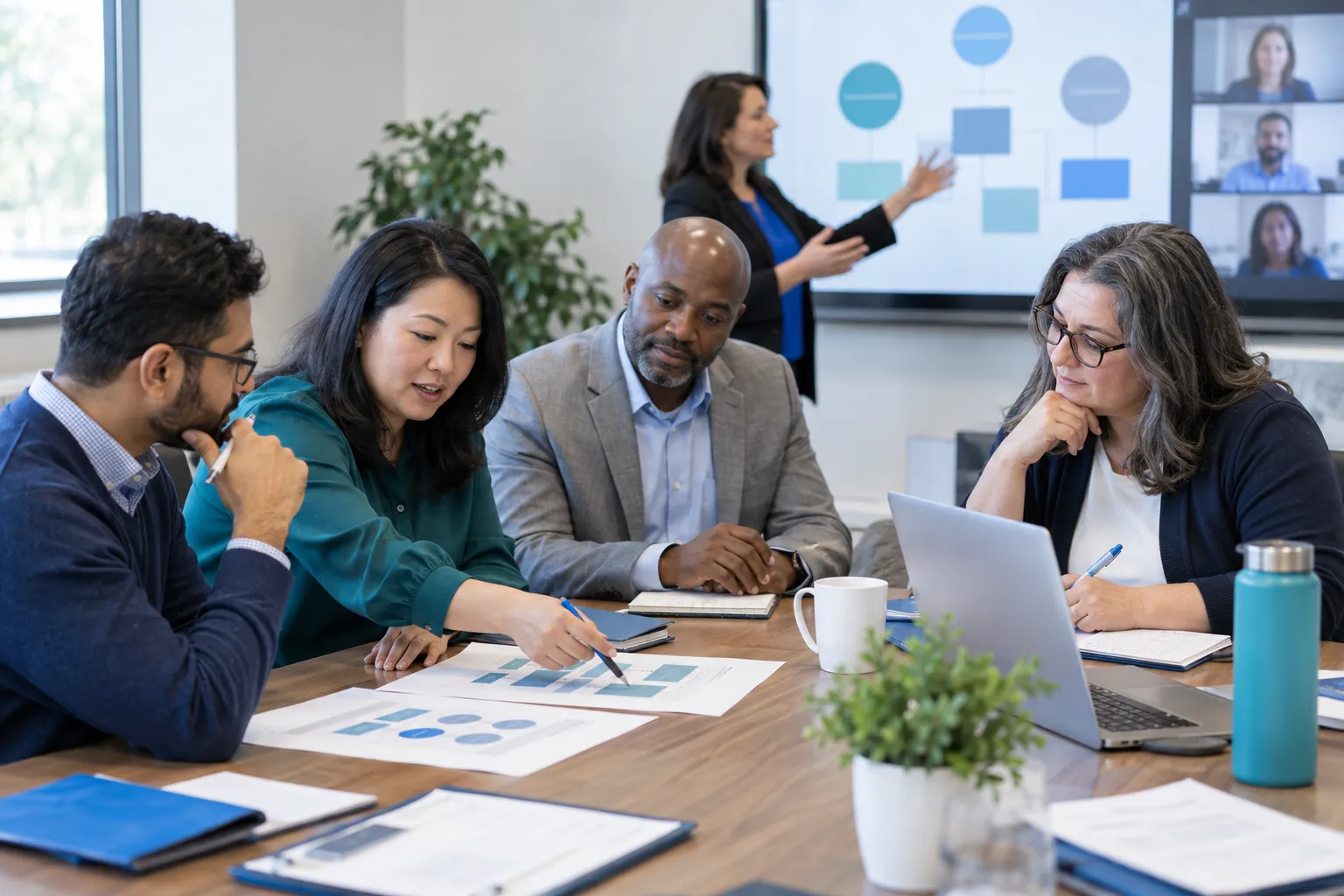 Diverse adult learners in a procurement governance training classroom with laptops and notebooks