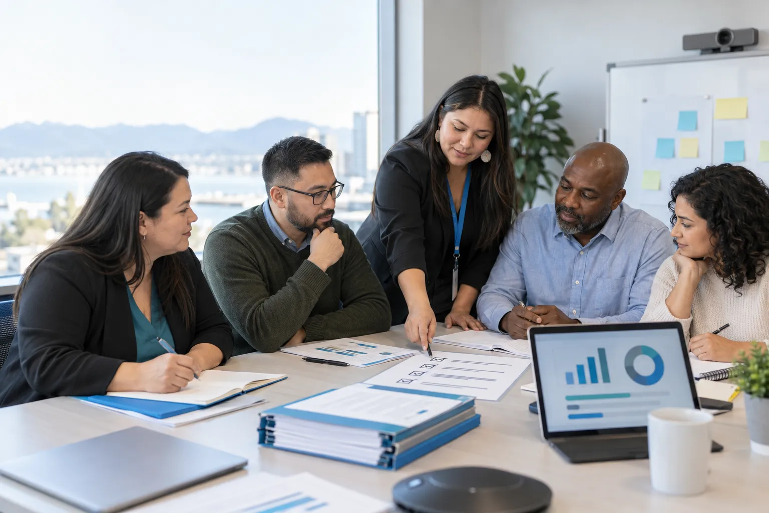 Diverse adult learners with laptops and notebooks in a procurement training session
